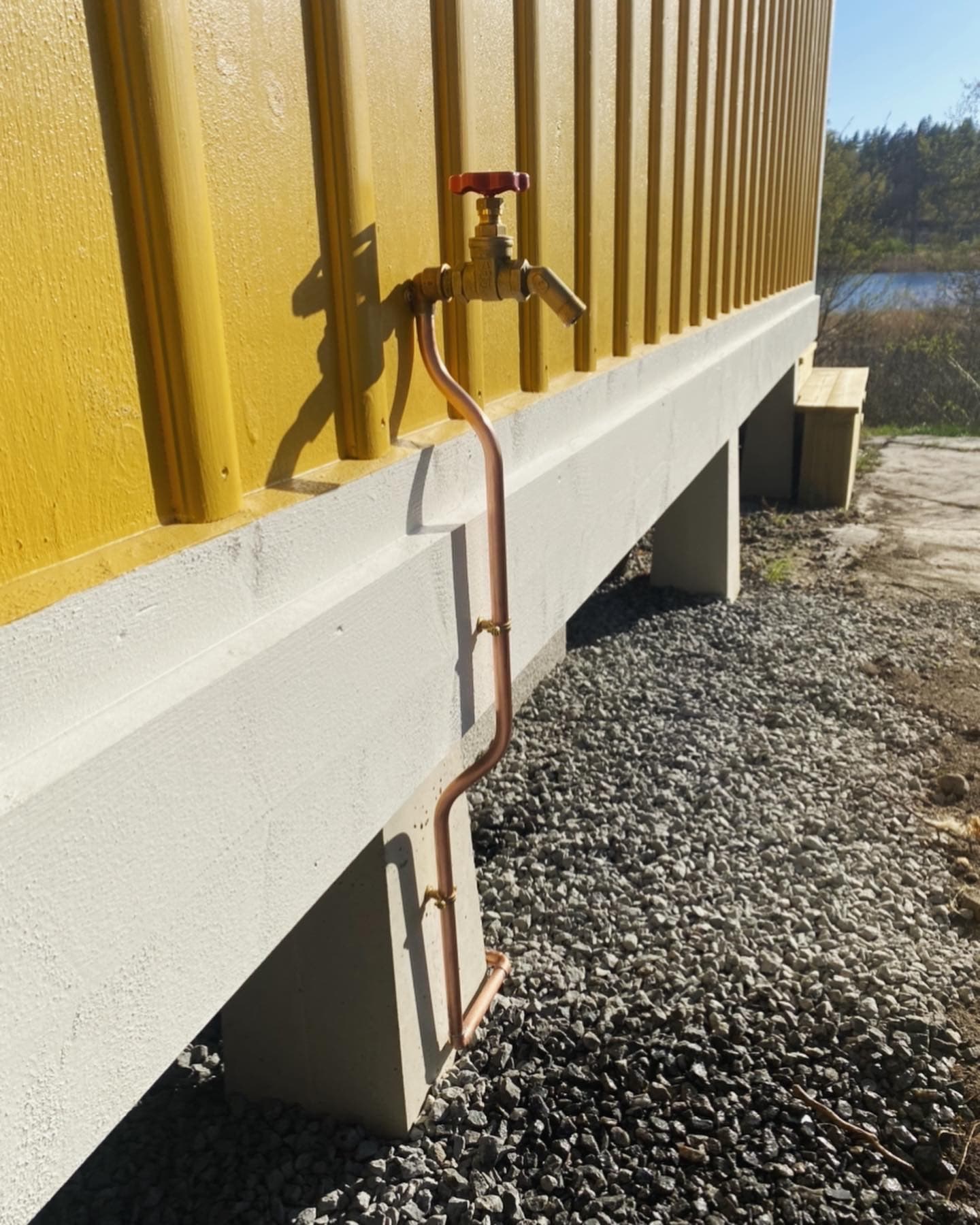 Utvändig vattenkran och dragning av kopparrör längs en fasad